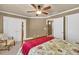 Cozy bedroom features a four-poster bed with a floral comforter and ceiling fan at 3125 Flatbottom Dr, Dacula, GA 30019