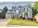 Charming two-story home featuring a manicured lawn, brick accents, and a welcoming front porch with black shutters at 3125 Flatbottom Dr, Dacula, GA 30019