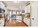 Bright kitchen featuring white cabinets, granite countertops and stainless steel appliances, seamlessly connected to the dining area at 3125 Flatbottom Dr, Dacula, GA 30019