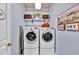Efficient laundry room with modern washer and dryer, shelving, and decorative touches for a functional space at 3125 Flatbottom Dr, Dacula, GA 30019