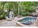 A private backyard with a stone fireplace, in-ground pool, and a patio at 4627 Angelo Ne Dr, Atlanta, GA 30319
