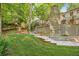 Lush backyard with steps leading up to a stone fireplace and second story porch at 4627 Angelo Ne Dr, Atlanta, GA 30319