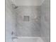 Bathroom with a white tiled shower and bathtub combo featuring a shower head and faucet, and a storage niche at 464 Pine Tree Ne Dr, Atlanta, GA 30305