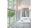 Bright bathroom features a large window, a white sink and vanity with quartz countertops, and modern lighting fixtures at 464 Pine Tree Ne Dr, Atlanta, GA 30305