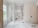 Beautifully tiled walk-in shower with marble floors, built-in bench, and an alcove for toiletries at 464 Pine Tree Ne Dr, Atlanta, GA 30305