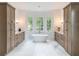 Modern bathroom boasts a freestanding tub, marble floors, stylish vanities, and plentiful natural light at 464 Pine Tree Ne Dr, Atlanta, GA 30305