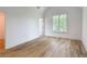 Bedroom with hardwood floors, white trim, large window and neutral colored walls at 464 Pine Tree Ne Dr, Atlanta, GA 30305