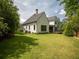 A sprawling home features a vast lawn, with lush landscaping and private outdoor living on the covered patio at 464 Pine Tree Ne Dr, Atlanta, GA 30305