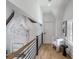 Hallway with hardwood floors, stone fireplace, wood railing, and a comfortable chair at 464 Pine Tree Ne Dr, Atlanta, GA 30305