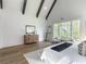 Bright main bedroom featuring vaulted ceiling beams, hardwood floors, and natural light from the expansive windows at 464 Pine Tree Ne Dr, Atlanta, GA 30305