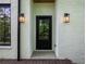 Charming side door with glass panes and sconce lighting against white brick at 464 Pine Tree Ne Dr, Atlanta, GA 30305