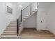 Staircase features light wood treads, white risers and walls, a black metal railing, and hardwood flooring at 464 Pine Tree Ne Dr, Atlanta, GA 30305