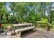 Outdoor deck with a dining table, bench, chairs and views of the wooded yard at 960 Lindridge Ne Dr, Atlanta, GA 30324