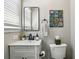 Well-lit bathroom featuring a framed mirror, colorful artwork and classic white fixtures at 960 Lindridge Ne Dr, Atlanta, GA 30324