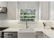Bright kitchen featuring a farmhouse sink beneath a window overlooking the trees at 960 Lindridge Ne Dr, Atlanta, GA 30324