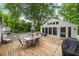 Outdoor deck with a table and chair set, umbrella, and a beautiful treed backyard at 97 Peachtree Hills Ne Ave, Atlanta, GA 30305