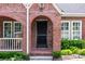 Quaint brick front entrance with arched doorway, manicured bushes, and stylish lighting at 97 Peachtree Hills Ne Ave, Atlanta, GA 30305