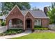 Charming brick Tudor home features a covered porch and a lush, well-manicured front lawn at 97 Peachtree Hills Ne Ave, Atlanta, GA 30305