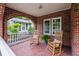 Inviting front porch with brickwork, tile flooring, and rocking chairs at 97 Peachtree Hills Ne Ave, Atlanta, GA 30305