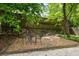 Outdoor patio features gravel flooring and a bistro table surrounded by trees and lush vegetation at 97 Peachtree Hills Ne Ave, Atlanta, GA 30305