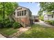 Back of house featuring a large deck with stairs, brick first level, and a treed yard at 97 Peachtree Hills Ne Ave, Atlanta, GA 30305