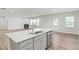 Kitchen island with stainless steel dishwasher and a view of the living room fireplace at 205 Kindness Cir, Mcdonough, GA 30252
