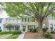 Charming townhome with light yellow siding, dark blue shutters, front yard foliage, and a mature shade tree at 3746 Berkeley Xing, Duluth, GA 30096