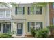 Charming townhome featuring light yellow siding, dark blue shutters, and a small balcony over the entry door at 3746 Berkeley Xing, Duluth, GA 30096