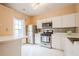 Bright kitchen features white cabinetry, stainless steel appliances, and breakfast bar at 3746 Berkeley Xing, Duluth, GA 30096
