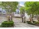 Brick townhome featuring a two-car garage and a charming covered entrance, complemented by mature trees and manicured landscaping at 6080 Indian Wood Se Cir, Mableton, GA 30126