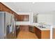 Modern kitchen features stainless steel appliances, dark wood cabinets, and a convenient breakfast bar overlooking the living area at 6080 Indian Wood Se Cir, Mableton, GA 30126