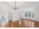 Open living room features hardwood floors, chandelier, and natural light from the windows at 6080 Indian Wood Se Cir, Mableton, GA 30126