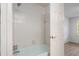 This bathroom features white tiled walls, a shower and tub combo, and a door to another room at 70 Old Ivy Ne Rd # 29, Atlanta, GA 30342