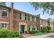 Charming brick townhouse featuring traditional shutters, manicured landscaping, and a welcoming green front door at 70 Old Ivy Ne Rd # 29, Atlanta, GA 30342