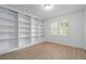 A home office with built in shelving, neutral walls, hardwood floors and natural light at 70 Old Ivy Ne Rd # 29, Atlanta, GA 30342