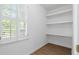 Bright pantry featuring wood floors, a window with shutters, and open shelving for optimal storage at 70 Old Ivy Ne Rd # 29, Atlanta, GA 30342