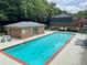Refreshing community pool with lounge chairs and nearby brick pool house at 70 Old Ivy Ne Rd # 29, Atlanta, GA 30342