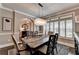 Elegant dining room featuring a modern chandelier, dark wood table, and shutters for natural light at 7725 Pierpoint Ln, Alpharetta, GA 30005