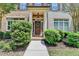 Inviting townhome entryway with lush landscaping and covered porch at 7725 Pierpoint Ln, Alpharetta, GA 30005