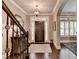 Elegant foyer featuring hardwood floors, staircase with wrought iron railing, and stylish lighting at 7725 Pierpoint Ln, Alpharetta, GA 30005