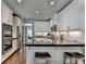Well-lit kitchen with stainless steel appliances, white cabinets, subway tile backsplash, and dark countertops at 7725 Pierpoint Ln, Alpharetta, GA 30005