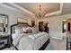 Spacious main bedroom boasts neutral walls, a chandelier, and a large bed with stylish bedding at 7725 Pierpoint Ln, Alpharetta, GA 30005