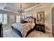 Luxurious main bedroom with tray ceiling, chandelier, neutral walls, and beautiful windows at 7725 Pierpoint Ln, Alpharetta, GA 30005