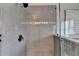 Modern bathroom shower with gray tiles, sleek fixtures, and frameless glass enclosure at 7725 Pierpoint Ln, Alpharetta, GA 30005