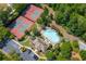 This overhead shot highlights a swimming pool, tennis courts, and parking lot integrated within a lush, tree-filled environment at 9889 Between The Grns, Villa Rica, GA 30180