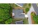 Birds eye view of a home featuring a dark roof, driveway, manicured landscaping and a back patio area at 9889 Between The Grns, Villa Rica, GA 30180