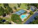 Aerial view of community pool and tennis courts with ample parking, all surrounded by lush greenery and mature trees at 9889 Between The Grns, Villa Rica, GA 30180