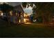 Beautiful backyard with a patio, trees, and exterior lighting illuminating the landscape at dusk at 9889 Between The Grns, Villa Rica, GA 30180