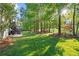 Spacious backyard with mature trees, a wooden swing, and a deck with stairs leading up to the house at 9889 Between The Grns, Villa Rica, GA 30180