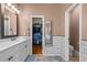 Well-lit bathroom provides a double vanity and access to a spacious walk-in closet at 9889 Between The Grns, Villa Rica, GA 30180